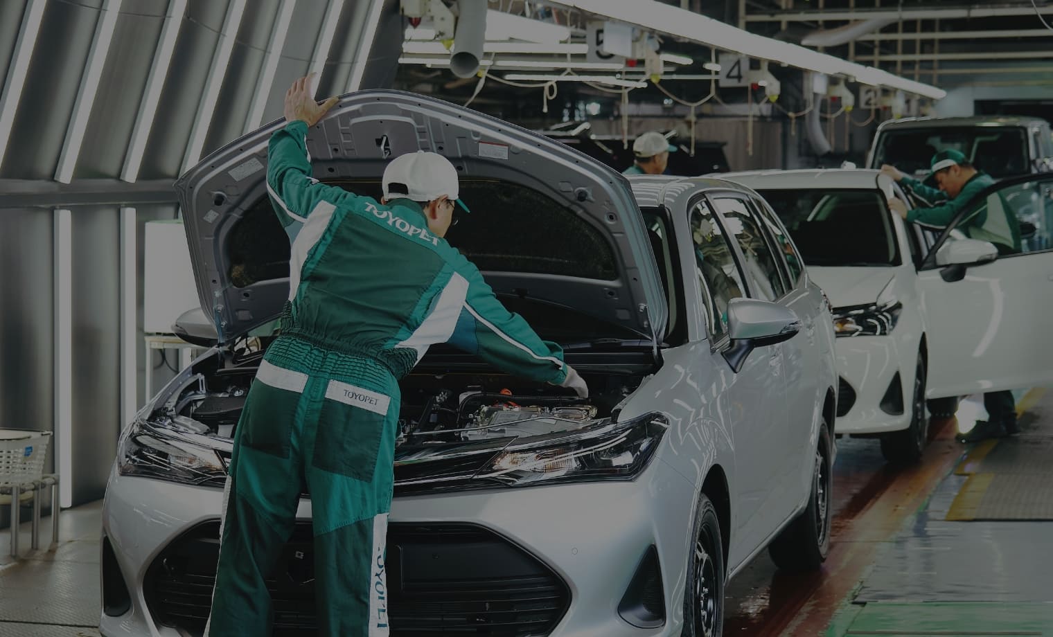 ボンネットに手をかけてエンジンを見ている男性