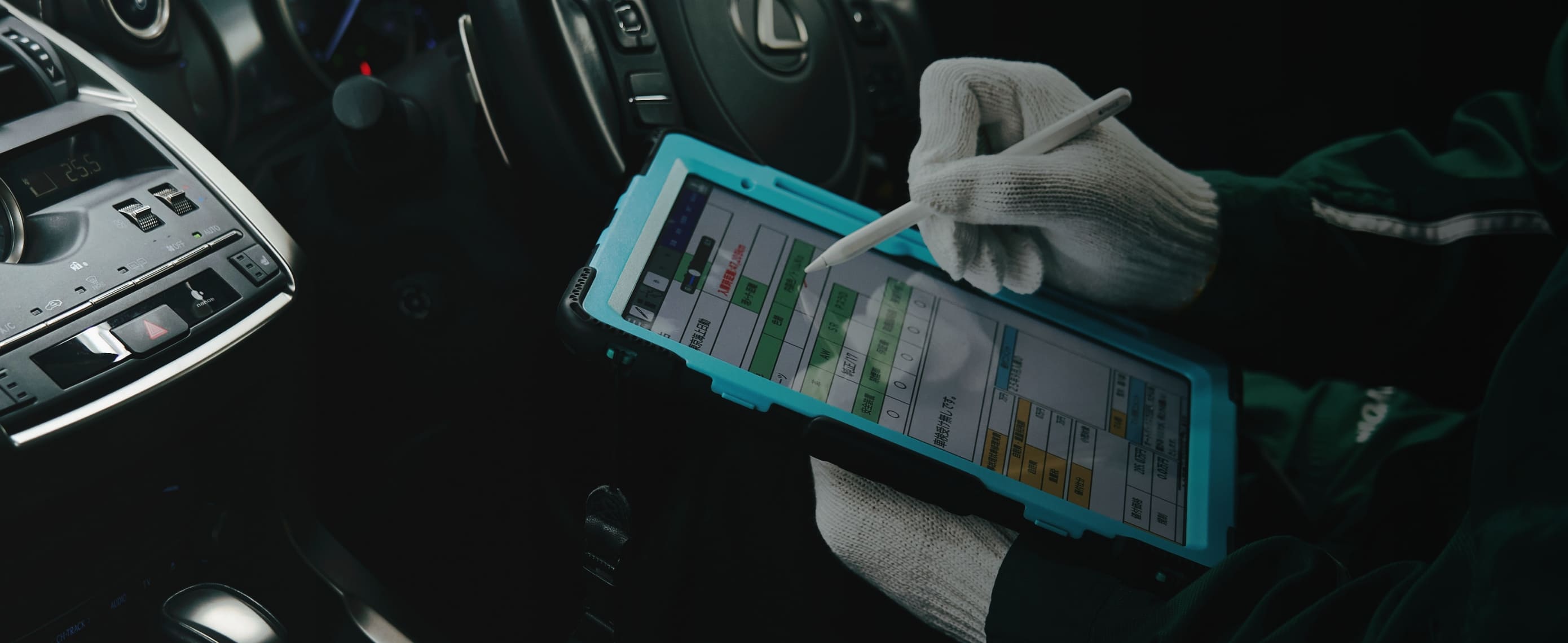 タブレットを用いて中古車の状態をチェックしている様子