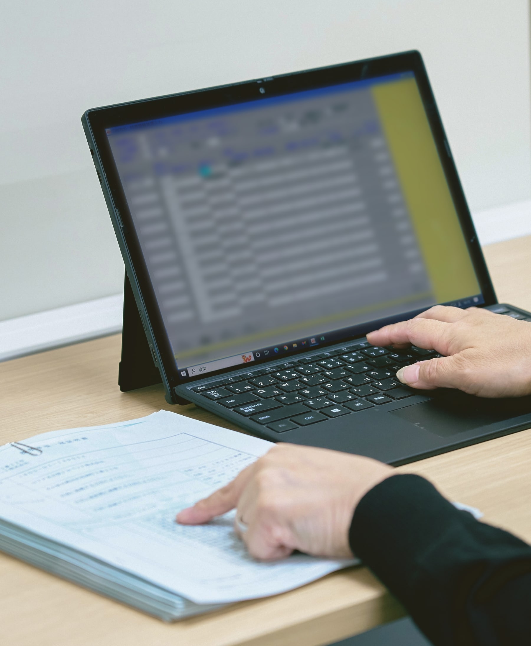 データを指差し確認しながらノートパソコンで入力している様子