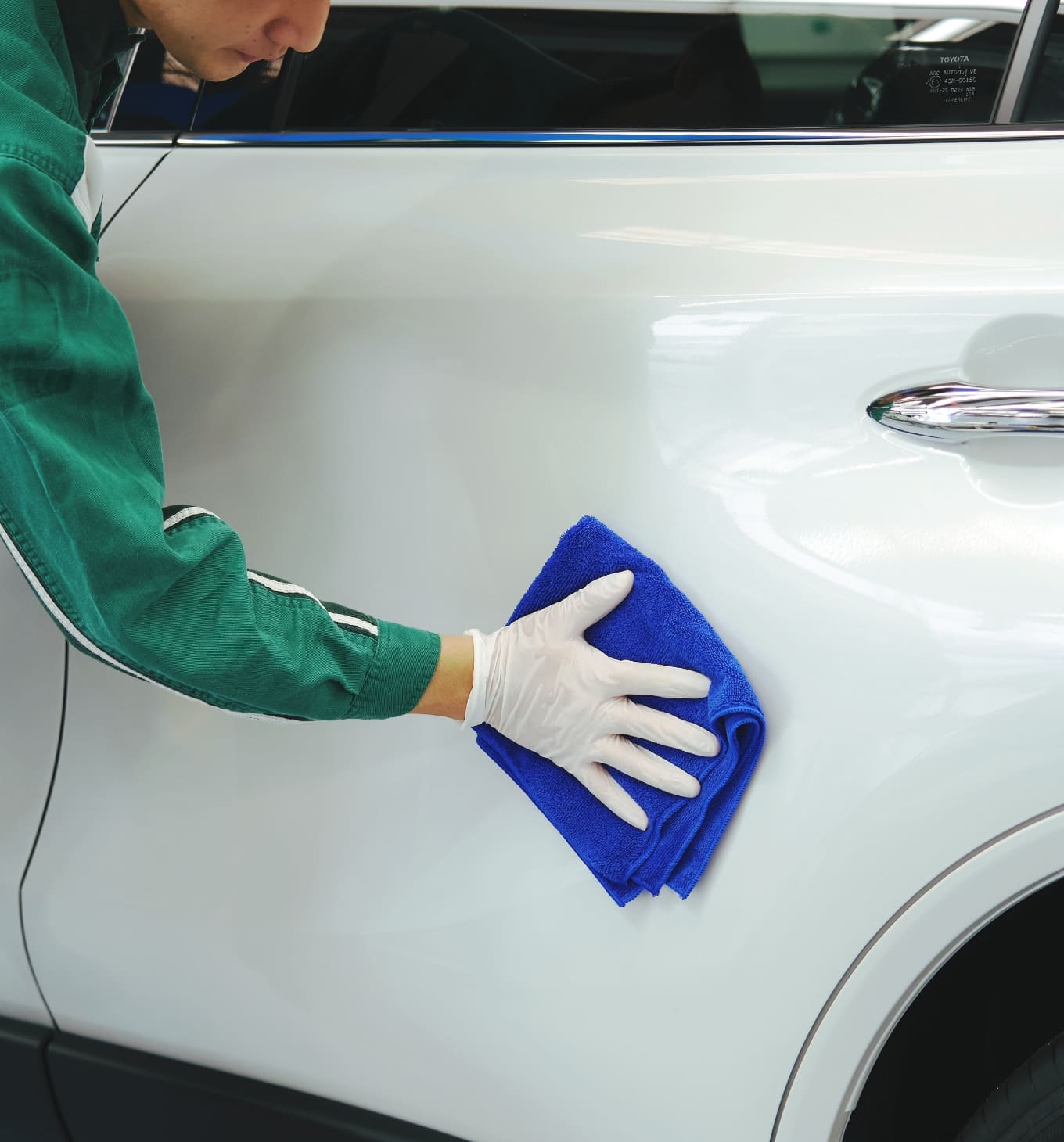 車のボディをウェスで拭いている様子